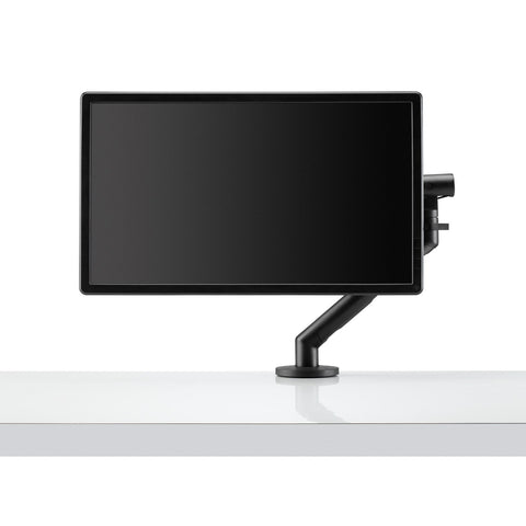 Front view of Flo single black monitor arm mounted on a desk with a monitor attached to it.