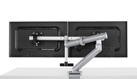 Back view of Flo Plus dual monitor arm in silver and black color attached to a desk clamp