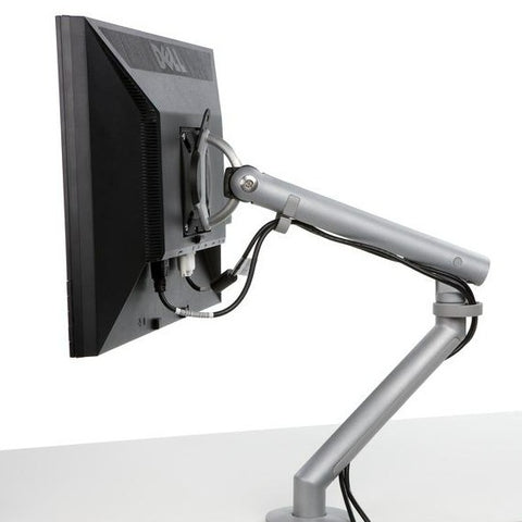 Back view of Flo single monitor arm mounted on a desk with a monitor, featuring adjustable clamp
