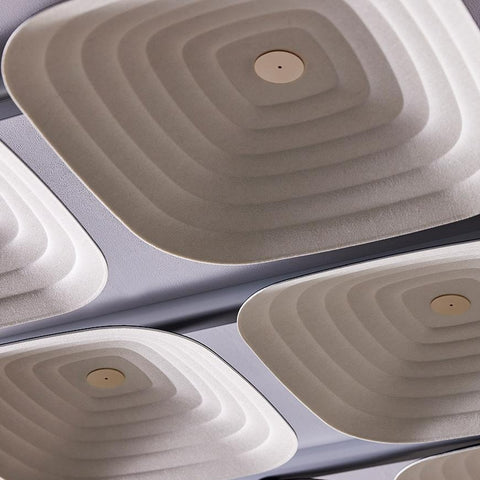 A close-up of Fuji Roku square beige 3D acoustic tiles with a woven pattern, fixed to the ceiling.