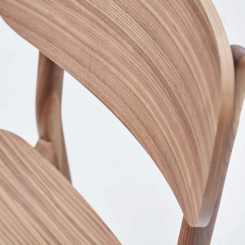 Close up of Okidoki chair with a plywood seat and backrest in walnut color.