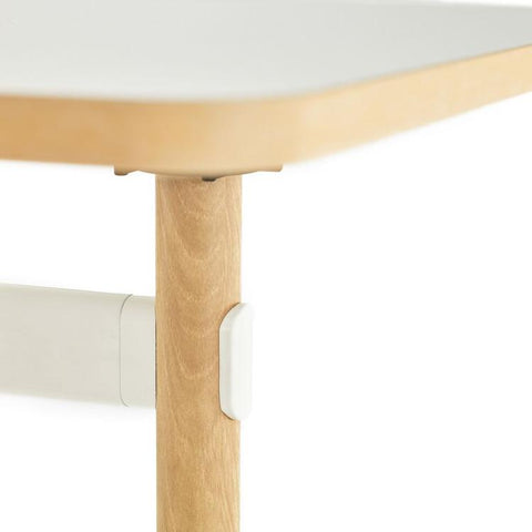 Close up of Okidoki rectangle folding table with a white frame and ash wooden legs