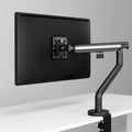 Black Glider monitor arm mounted on a white desk, holding a single monitor
