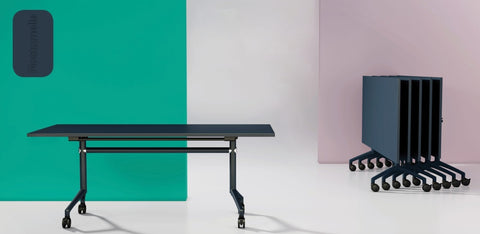 I.AM folding tables with navy tops and black frames, shown side by side in upright and folded stackable positions
