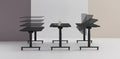 Three black Jojo Electric Folding Tables side by side with castor feet, showing height adjustment, standard desk setup, and foldable option