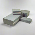 Stack of Keen Drama Blocks in light grey upholstery, showcasing custom fabric options and durable construction for school staging and classroom use