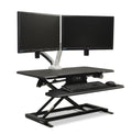 Vertilift Pro desk riser in black with keyboard platform and dual monitors at standing height