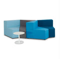 An angular modular lounge set arranged in a casual seating configuration with blue and gray upholstery, accompanied by round white table