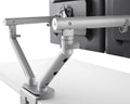 Close up back view of Flo dual monitor arm desk-clamp mounted with adjustable joints for angle and length