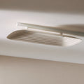 Fuji Juni beige long rectangular acoustic tile with art deco curve and embossed linework, fixed to a ceiling.