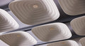 A close-up of Fuji Roku square beige 3D acoustic tiles with a woven pattern, fixed to the ceiling.