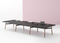A long, rectangular Okidoki+ conference table with multiple leg options, featuring a dark tabletop and light-colored frame